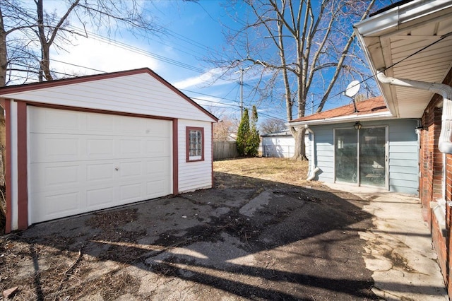 detached garage with driveway and fence