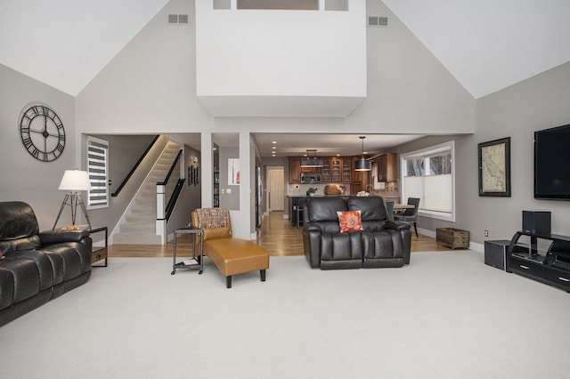 living area featuring visible vents, carpet flooring, stairway, and baseboards