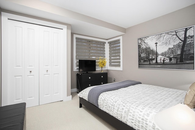 carpeted bedroom featuring a closet and baseboards