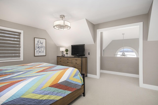 bedroom with baseboards, lofted ceiling, and light colored carpet