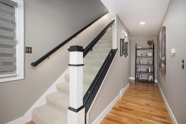 staircase featuring recessed lighting, baseboards, and wood finished floors