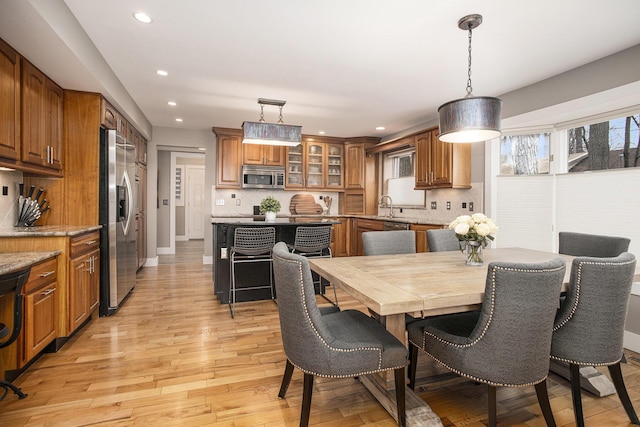 dining space with recessed lighting, light wood-type flooring, and baseboards