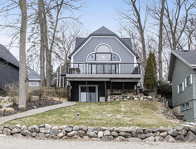 view of front of home featuring an attached garage, a front lawn, and a deck