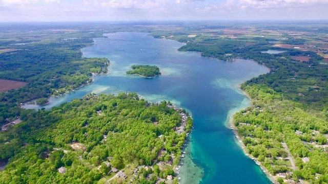 drone / aerial view with a forest view and a water view