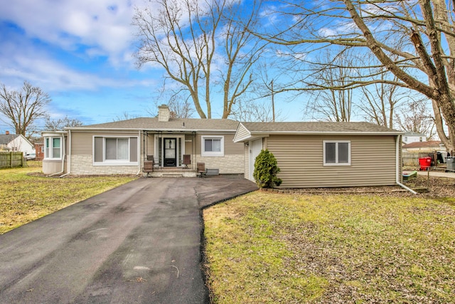 single story home featuring a front lawn, fence, driveway, and a chimney