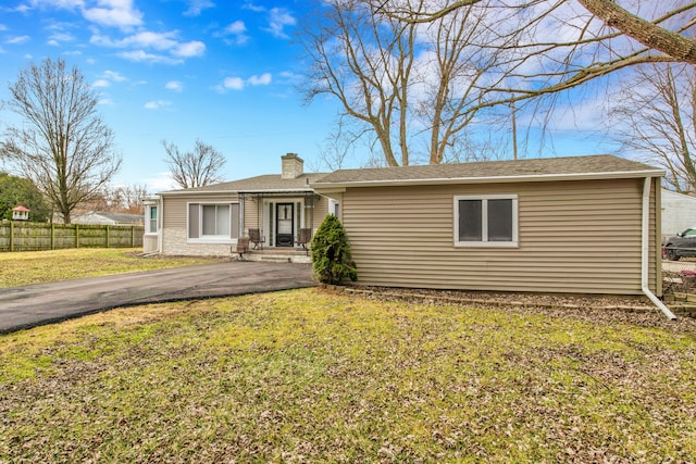 single story home with a front lawn, fence, driveway, and a chimney