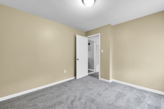 unfurnished bedroom with carpet flooring and baseboards