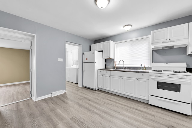 kitchen featuring visible vents, under cabinet range hood, washer / dryer, white appliances, and a sink