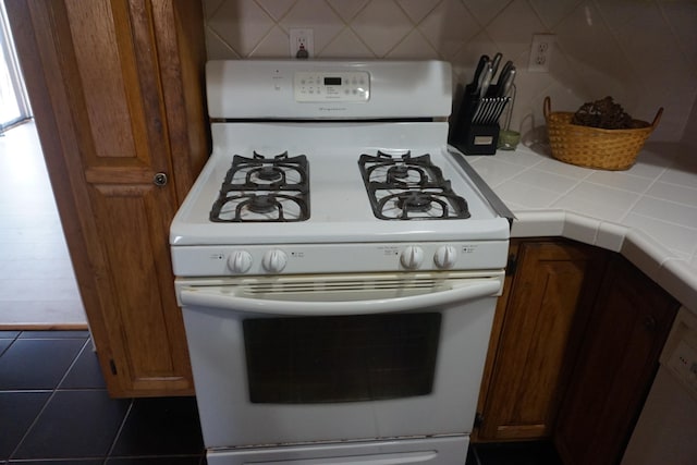 1758 Manor Rd, Au Gres, MI 48703 - kitchen with tile countertops, backsplash, and white gas range oven