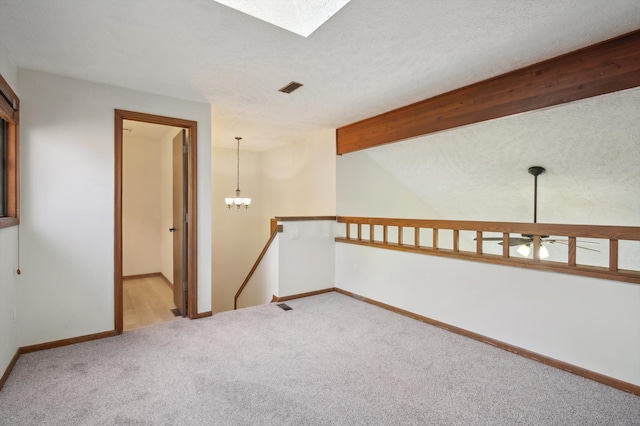 131 E Jolly Rd Unit E6, Lansing, MI 48910 - spare room with carpet, a skylight, baseboards, and a chandelier