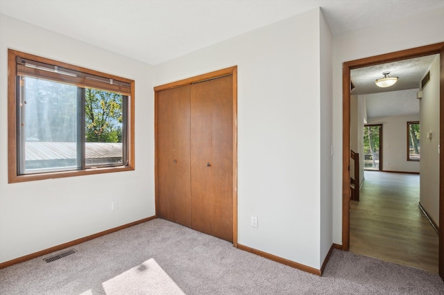 131 E Jolly Rd Unit E6, Lansing, MI 48910 - unfurnished bedroom featuring multiple windows, a closet, and baseboards