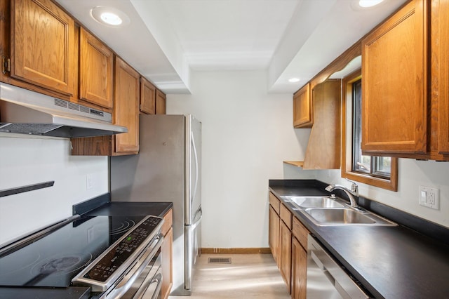 131 E Jolly Rd Unit E6, Lansing, MI 48910 - kitchen with under cabinet range hood, appliances with stainless steel finishes, a sink, dark countertops, and brown cabinetry