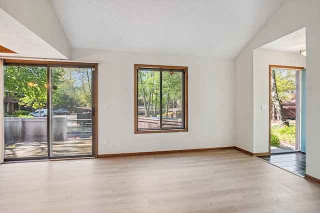 131 E Jolly Rd Unit E6, Lansing, MI 48910 - spare room featuring light wood finished floors, vaulted ceiling, and baseboards