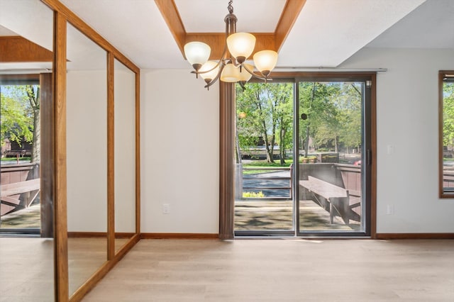 131 E Jolly Rd Unit E6, Lansing, MI 48910 - doorway featuring wood finished floors, a chandelier, and baseboards