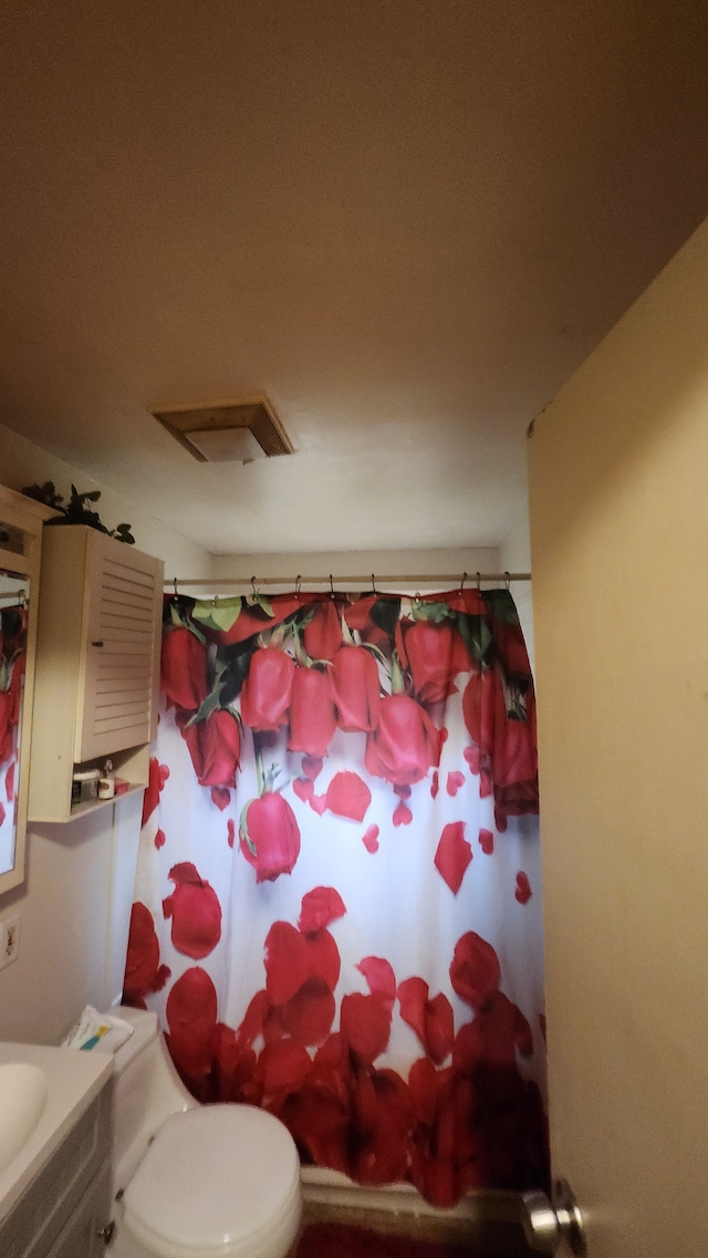 bathroom with visible vents, toilet, and a shower with curtain