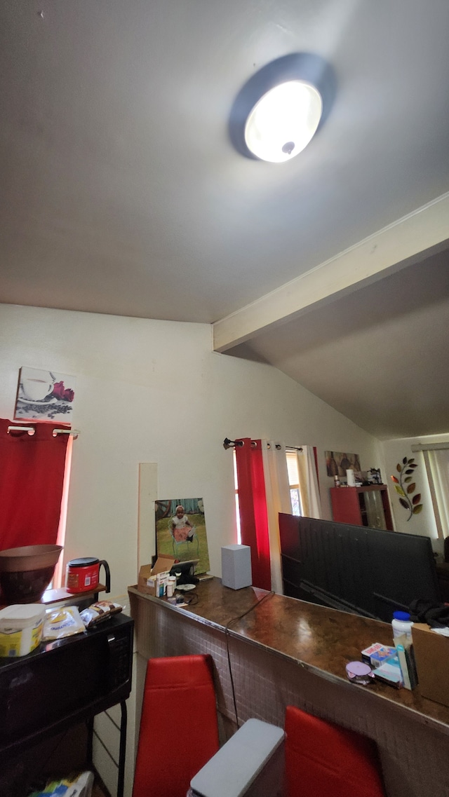 office area featuring vaulted ceiling with beams