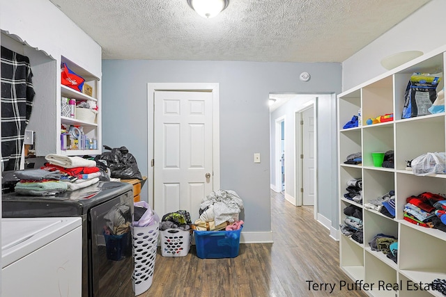 laundry room with washer and clothes dryer, wood finished floors, baseboards, and a textured ceiling