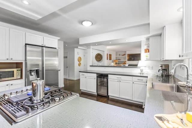 9696 Union Pier Rd, Union Pier, MI 49129 - kitchen featuring appliances with stainless steel finishes, beverage cooler, a sink, a peninsula, and white cabinets