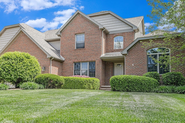 6317 Wilson Rd, Ann Arbor, MI 48108 - traditional-style house featuring brick siding, a front yard, and roof with shingles