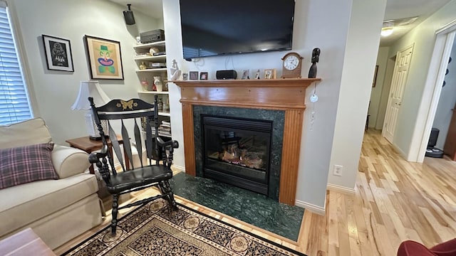 70255 51st St, Lawrence, MI 49064 - living area featuring a premium fireplace, baseboards, visible vents, and wood finished floors