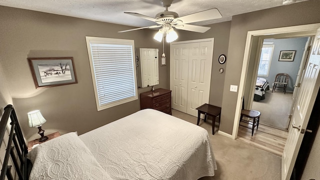 70255 51st St, Lawrence, MI 49064 - bedroom with light carpet, a textured ceiling, a ceiling fan, baseboards, and a closet