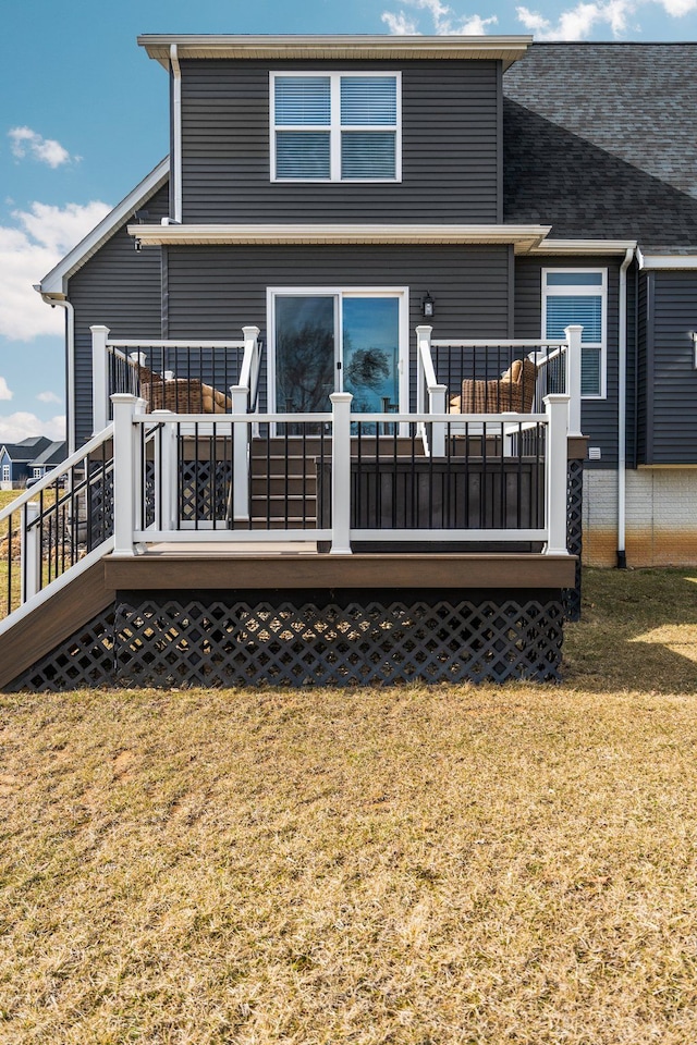 rear view of property with a yard and a wooden deck
