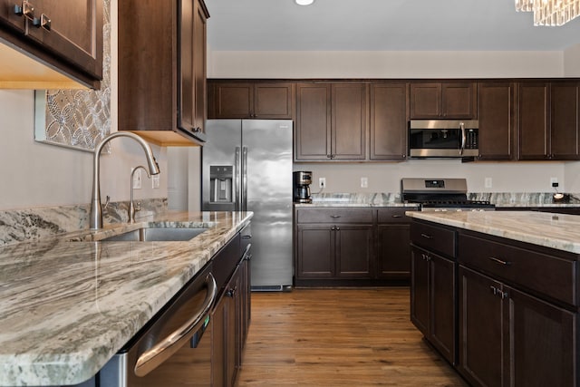 kitchen featuring a sink, dark brown cabinetry, and stainless steel appliances
