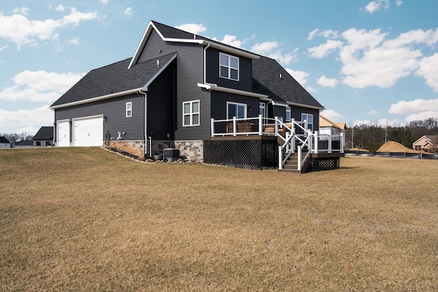 view of front of house featuring a shingled roof, a wooden deck, and a front yard