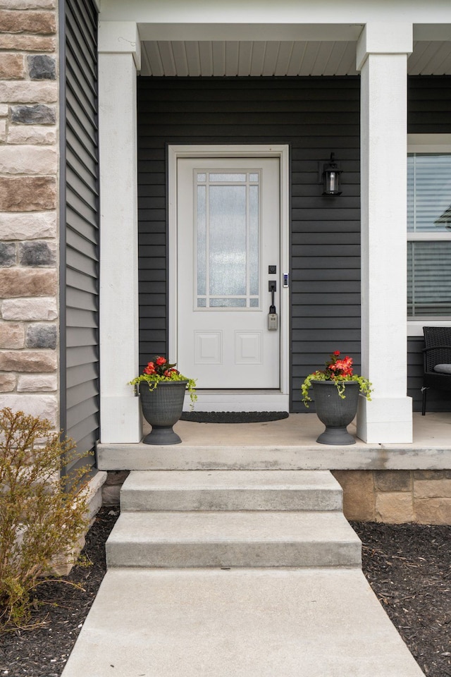 view of exterior entry featuring covered porch
