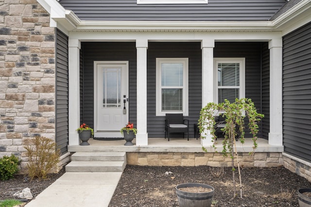 view of exterior entry featuring covered porch