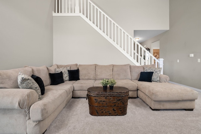 carpeted living area with stairs