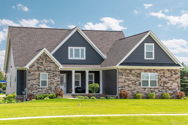 9931 Loretta Ln, South Lyon, MI 48178 - craftsman house featuring stone siding, covered porch, a front yard, and a shingled roof