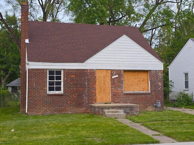 15876 Burt Rd, Detroit, MI 48223 - view of front of home with a chimney, a front yard, and a shingled roof