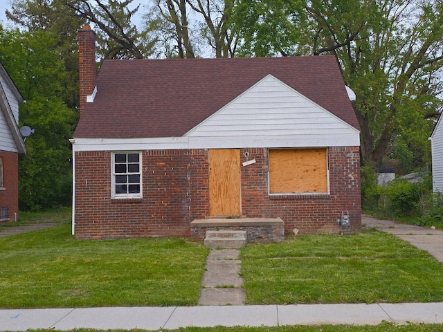 15876 Burt Rd, Detroit, MI 48223 - view of front of home with a chimney, brick siding, and a front yard
