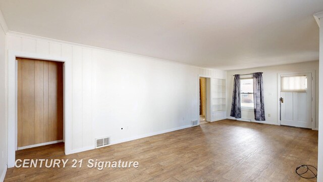 308 S Elm St, Saginaw, MI 48602 - unfurnished room with built in shelves, wood finished floors, visible vents, and baseboards