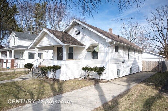 308 S Elm St, Saginaw, MI 48602 - view of side of home with fence, driveway, a yard, covered porch, and a chimney