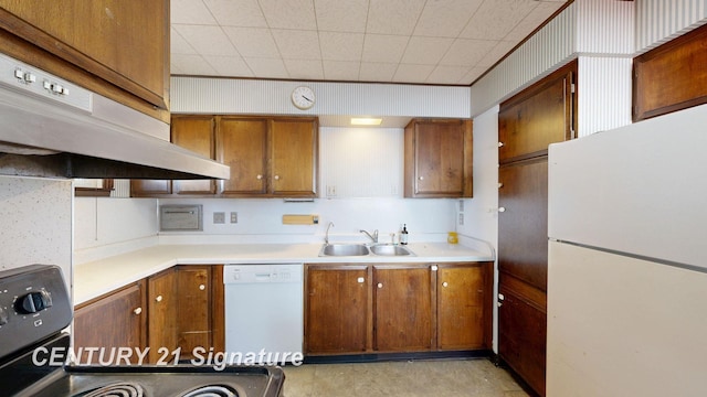 308 S Elm St, Saginaw, MI 48602 - kitchen featuring a sink, under cabinet range hood, white appliances, brown cabinetry, and light countertops