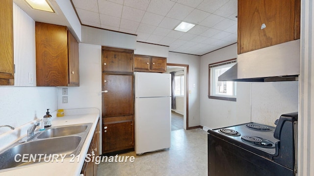 308 S Elm St, Saginaw, MI 48602 - kitchen featuring brown cabinetry, light floors, freestanding refrigerator, a sink, and black electric range oven