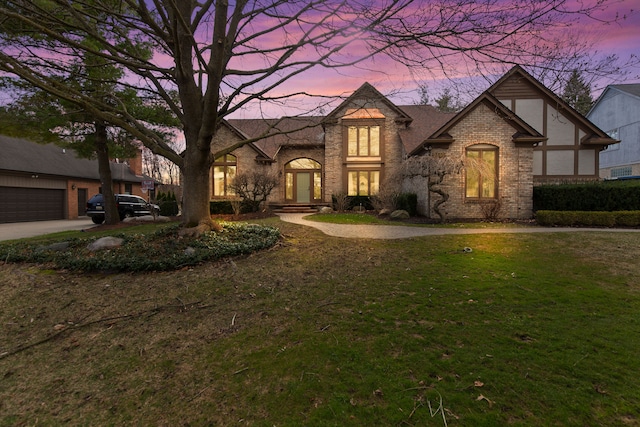 french country style house with brick siding and a lawn