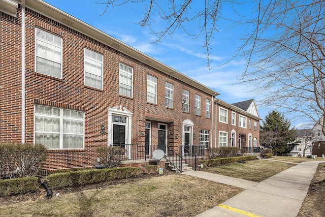 view of front of house with brick siding and a front lawn