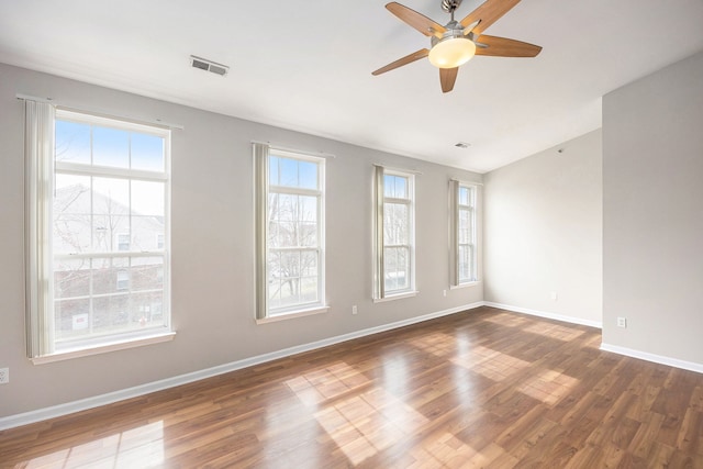 unfurnished room with visible vents, ceiling fan, baseboards, and wood finished floors