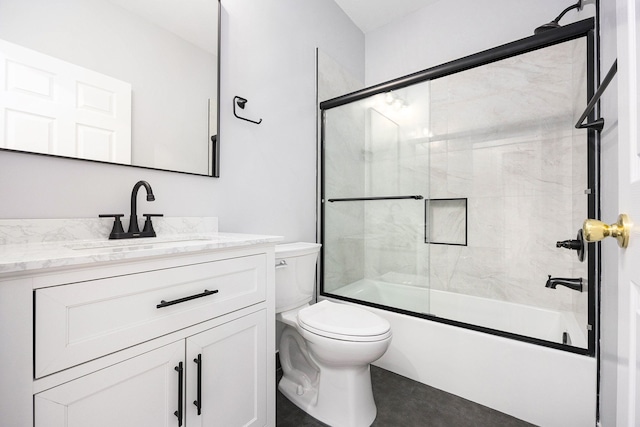 bathroom with vanity, toilet, and combined bath / shower with glass door