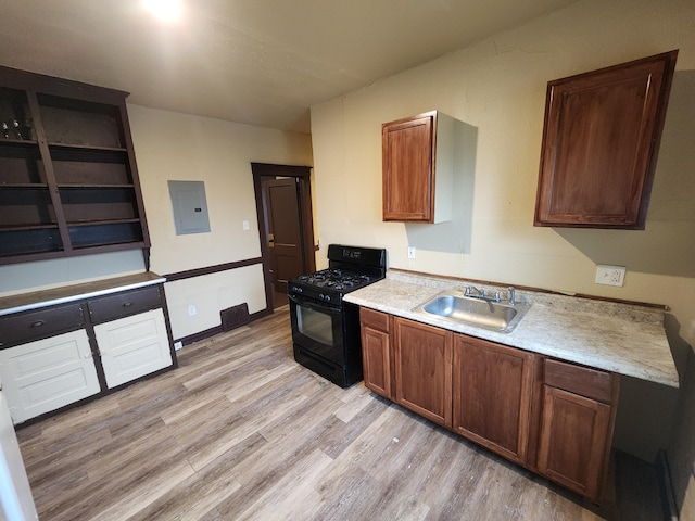 3491 Garland St, Detroit, MI 48214 - kitchen featuring black gas range oven, light countertops, electric panel, light wood-style flooring, and a sink