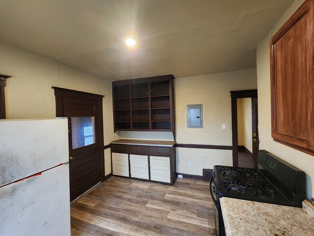 3491 Garland St, Detroit, MI 48214 - kitchen with black gas range oven, light wood finished floors, electric panel, freestanding refrigerator, and light countertops