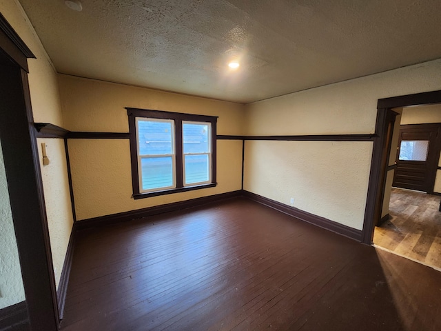 3491 Garland St, Detroit, MI 48214 - unfurnished room featuring baseboards, a textured ceiling, a textured wall, and wood-type flooring