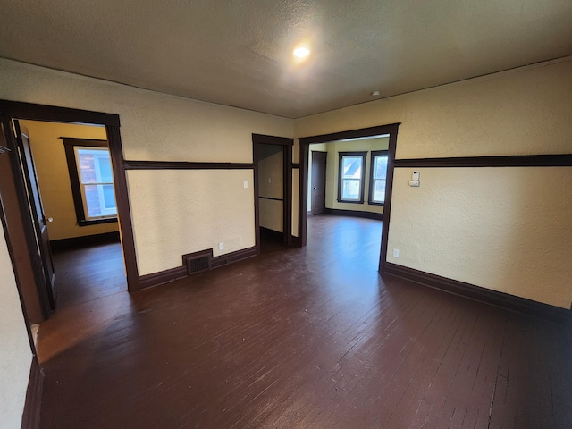 3491 Garland St, Detroit, MI 48214 - unfurnished room featuring a textured wall, visible vents, dark wood-style flooring, and baseboards