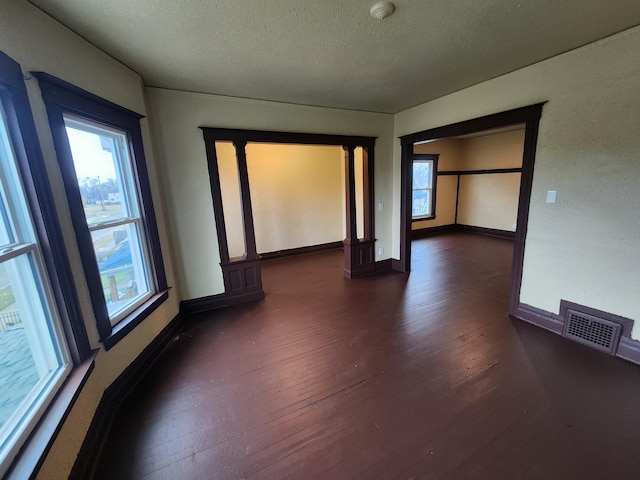 3491 Garland St, Detroit, MI 48214 - unfurnished room featuring dark wood finished floors, a healthy amount of sunlight, visible vents, and a textured ceiling