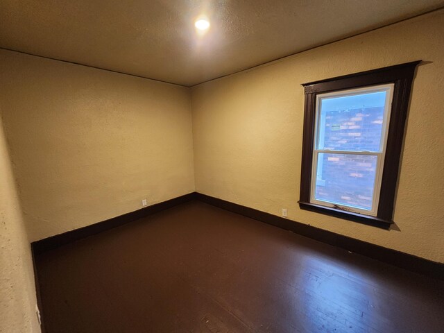 3491 Garland St, Detroit, MI 48214 - unfurnished room with dark wood finished floors, a textured wall, and baseboards