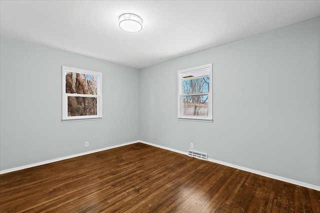 550 Royal Dr, Jackson, MI 49202 - spare room featuring dark wood-type flooring, baseboards, and visible vents