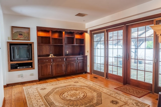 home office featuring light wood-style flooring, baseboards, and visible vents